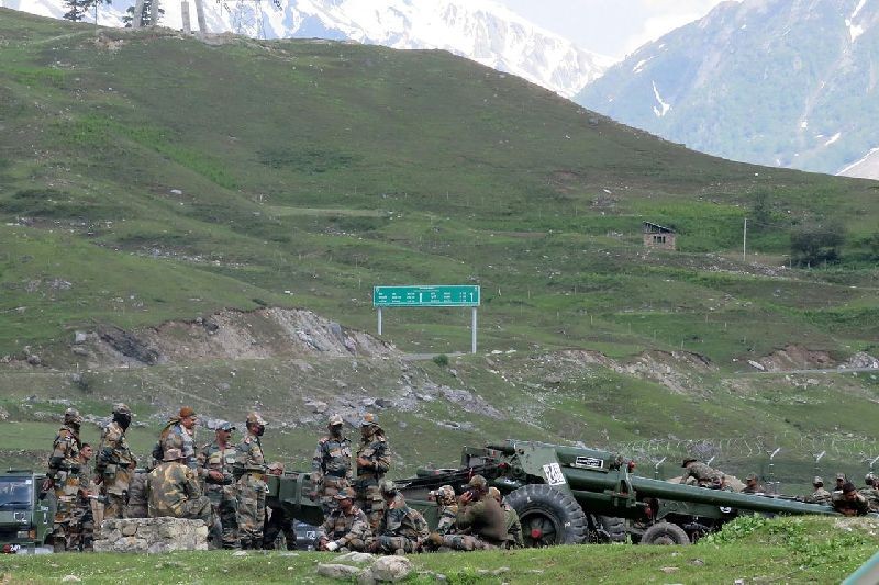 Indian army soldiers rest next to artillery guns at a makeshift transit camp before heading to Ladakh, near Baltal, southeast of Srinagar, June 16, 2020. REUTERS/Stringer